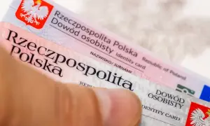 Zbliżenie na polski dowód osobisty trzymany przez palec.