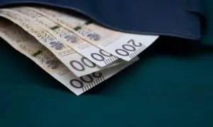 Złote banknoty 200 zł schowane w granatowym portfelu.