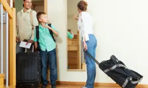 Rodzina gotowa na urlop. Ojciec z synem i walizkami, matka z torbą na kółkach. Czas na zasłużony odpoczynek, zgodnie z kodeksem pracy.