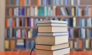 Stos książek na biurku, tło biblioteki z kolorowymi lekturami na e8.