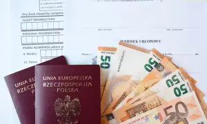 Paszporty i euro leżą obok wniosku urlopowego. Czy urlop okolicznościowy przepada, gdy brakuje środków na podróż?