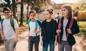 Grupa dzieci idzie razem, może planują wagary. Mają plecaki i wyglądają na podekscytowanych.
