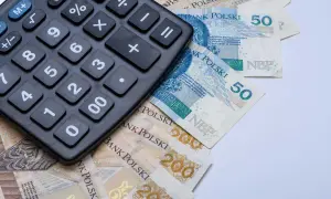 Kalkulator leżący na polskich banknotach 50 zł i 200 zł.