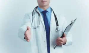 Lekarz w białym kitlu wyciąga rękę do uścisku, trzymając teczkę.