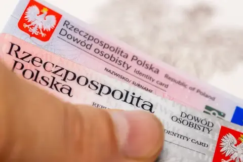 Zbliżenie na polski dowód osobisty trzymany przez palec.