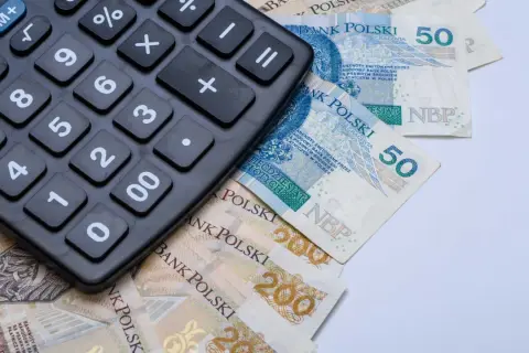 Kalkulator leżący na polskich banknotach 50 zł i 200 zł.