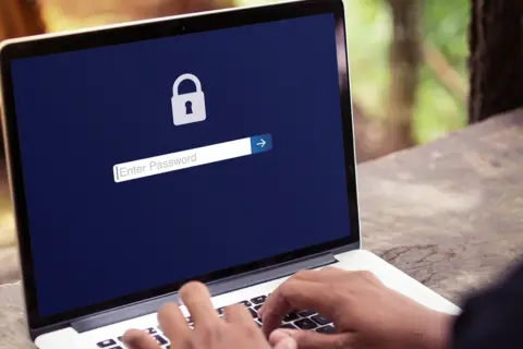 Laptop z ikoną kłódki i polem do wpisania hasła.