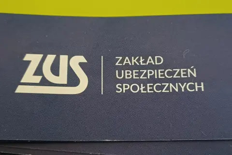 Logo ZUS (Zakład Ubezpieczeń Społecznych) na granatowym tle.