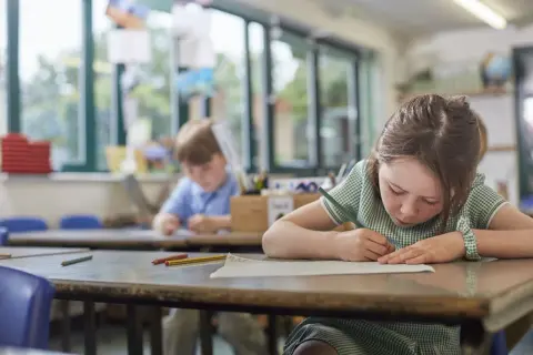 Dziewczynka z piegami skupiona na rysowaniu, obok niej chłopiec. Czy to zadanie na średnią ocenę 4?