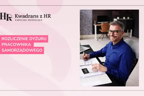 Uśmiechnięty mężczyzna w okularach rozlicza dyżur pracownika samorządowego. Jego dyspozycyjność jest kluczowa dla sprawnego funkcjonowania urzędu.