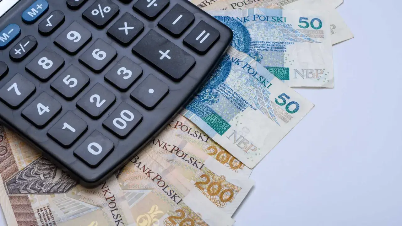 Kalkulator leżący na polskich banknotach 50 zł i 200 zł.