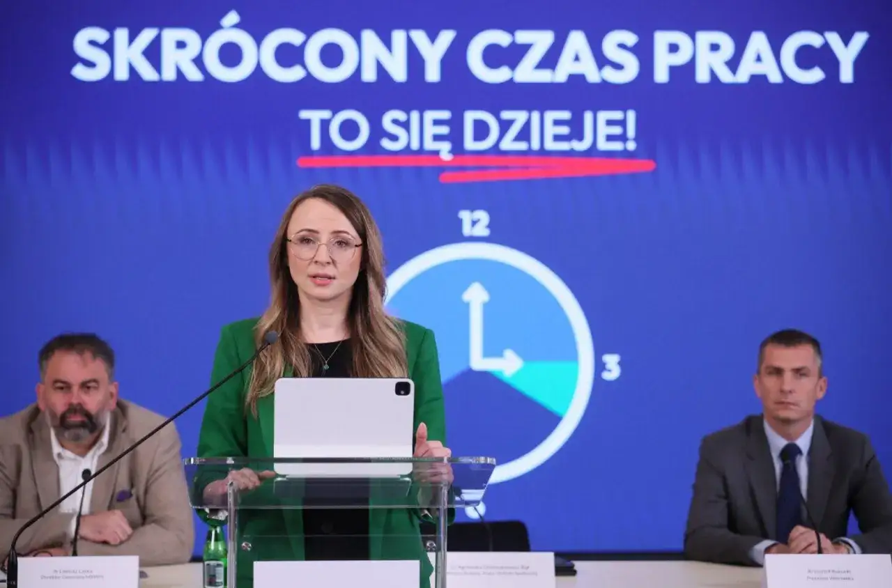 Kobieta przemawia na tle napisu 