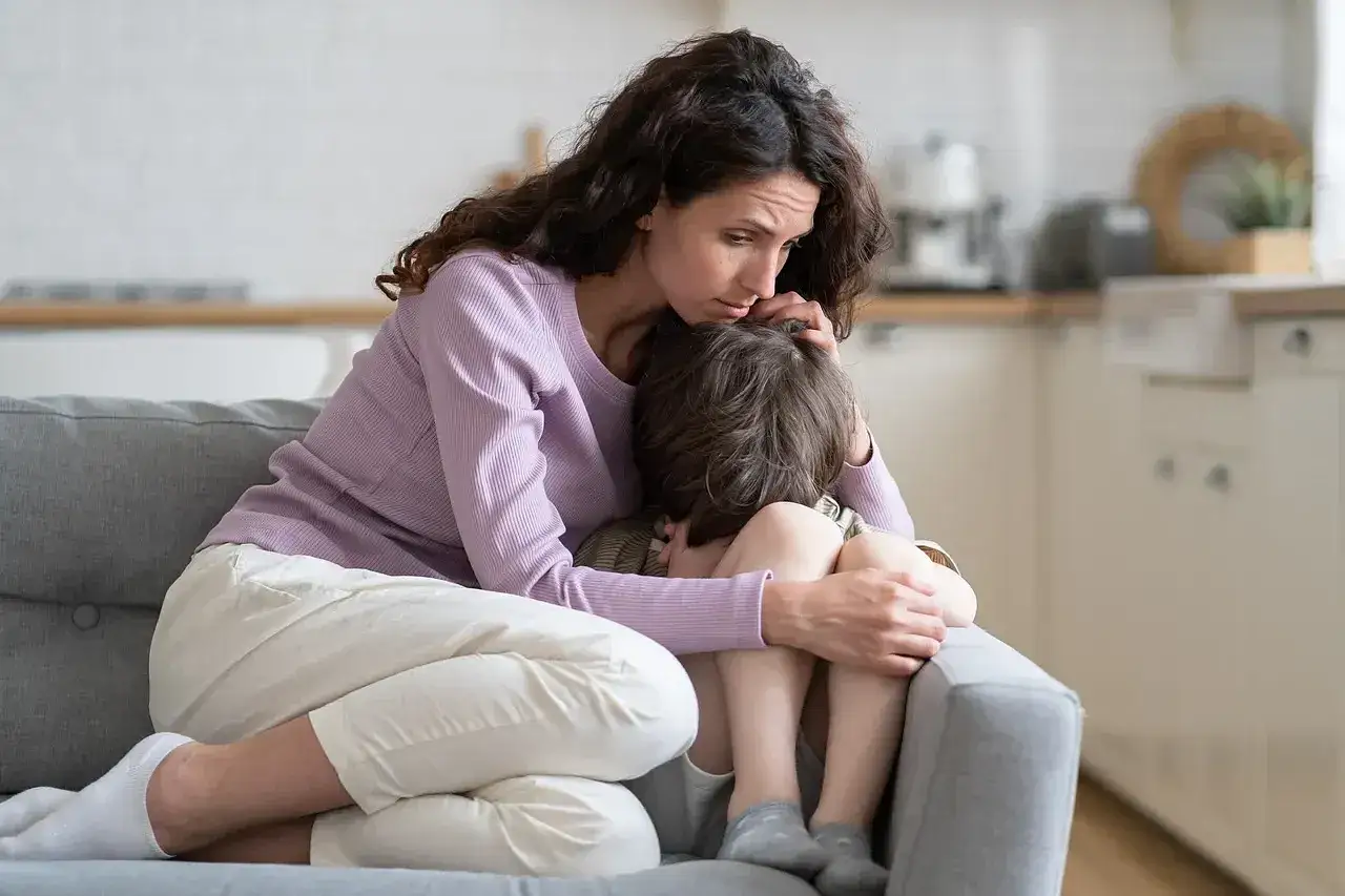 Zmartwiona mama pociesza płaczącego synka, który opowiedział o swoich wagary.