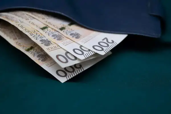 Złote banknoty 200 zł schowane w granatowym portfelu.