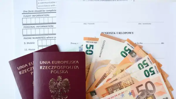 Paszporty i euro leżą obok wniosku urlopowego. Czy urlop okolicznościowy przepada, gdy brakuje środków na podróż?