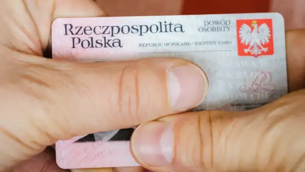 Dłonie trzymają polski dowód osobisty z widocznym godłem i napisem "Rzeczpospolita Polska".