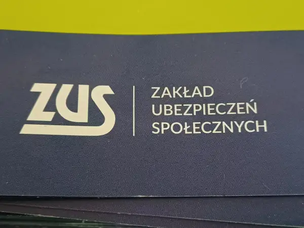 Logo ZUS (Zakład Ubezpieczeń Społecznych) na granatowym tle.