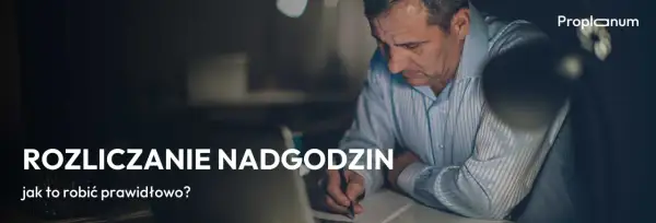 Mężczyzna pochyla się nad dokumentami, pisząc coś długopisem. Temat: rozliczanie nadgodzin, zgodnie z art. 151 kp.