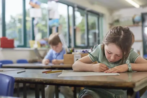 Dziewczynka z piegami skupiona na rysowaniu, obok niej chłopiec. Czy to zadanie na średnią ocenę 4?